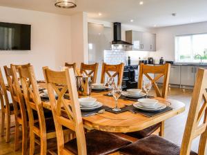 uma cozinha e sala de jantar com uma mesa de madeira e cadeiras em Chestnuts em Burgh by Sands