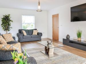 a living room with two couches and a tv at Chestnuts in Burgh by Sands