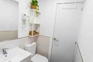 a white bathroom with a toilet and a shower at Villa Antolín in El Molar