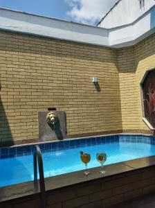a swimming pool with two wine glasses on a tile wall at Champion motel in Rio de Janeiro