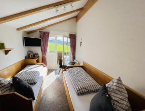 two beds in a room with a window at Ferienwohnungen Britta Heim in Oberstaufen
