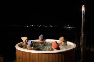a group of children in a hot tub at night at Catogården - Boutique Home & Activity Centre in Reine