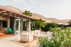 une terrasse avec 2 chaises blanches et quelques plantes dans l'établissement Casa Sua, à Famara