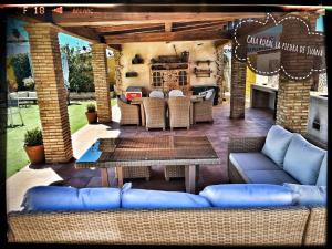 un patio con sofás azules y una mesa en Casa Rural La Piedra De Juana en Malpartida de Cáceres