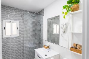 a bathroom with a sink and a shower and a mirror at Villa Antolín in El Molar