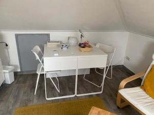 Poortugaal的住宿－Valckesteyn，一张白色的桌子和三把椅子