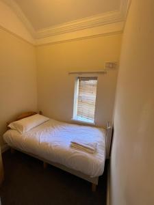 een kleine slaapkamer met een bed en een raam bij East City Flat in Dublin