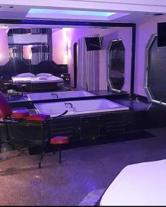 a room with a tub and chairs and purple lights at Champion motel in Rio de Janeiro