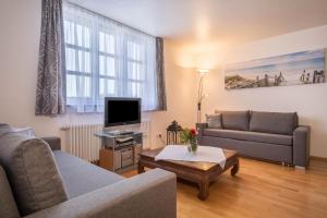 ein Wohnzimmer mit einem Sofa und einem TV in der Unterkunft Appartement Rathausplatz in Kempten