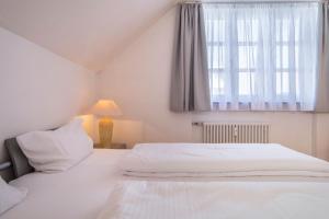 a bedroom with two white beds and a window at Appartement Rathausplatz in Kempten