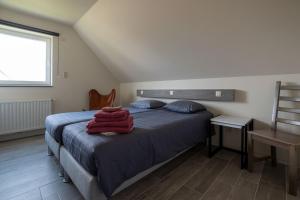 Un dormitorio con una cama con una manta roja. en Logies Ternier en Nieuwpoort