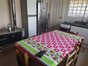 une cuisine avec une table et un chiffon rouge et vert dans l'établissement Casa Beira Rio, à Urubici