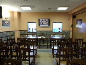uma sala de jantar com mesas e cadeiras de madeira em Hostal 2 estrellas -Restaurante Las Tres Encinas em Cabeza la Vaca