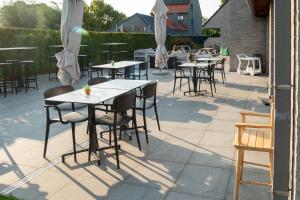 - une rangée de tables et de chaises sur la terrasse dans l'établissement Logies Ternier, à Nieuport