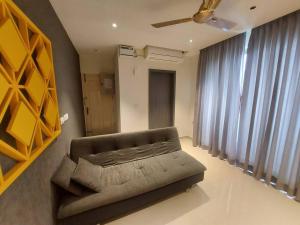 a living room with a couch and a ceiling fan at Lovely 1bedroom compact condo at 9th floor in Kelambākkam