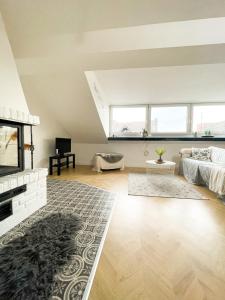 een woonkamer met een bank en een open haard bij Ginius Homes- Penthouse Düren in Düren - Eifel