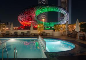 a pool in front of a building at night at Millennium Plaza Downtown Suites in Dubai