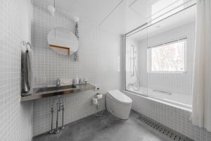 ein Badezimmer mit einem WC, einem Waschbecken und einem Spiegel in der Unterkunft 6ty6 Vacation Home in Niseko