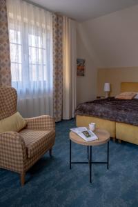 ein Hotelzimmer mit einem Bett, einem Stuhl und einem Tisch in der Unterkunft Highland Warmia - Gospodarstwo agroturystyczne in Jeziorany