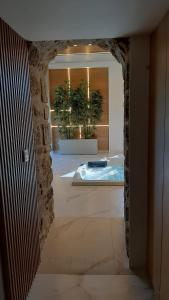 a hallway with a tub in a room with two plants at Casa do Engenho Braga in Braga