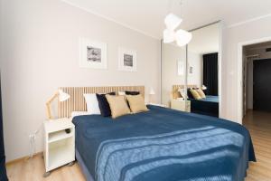 a bedroom with a blue bed and a mirror at Przystań Koło Brzegu in Kołobrzeg