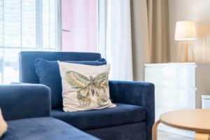 un cuscino a farfalla su una sedia blu in soggiorno di Przystań Koło Brzegu a Kołobrzeg