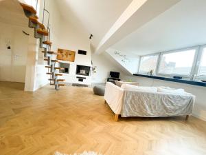 een woonkamer met een bank en een trap bij Ginius Homes- Penthouse Düren in Düren - Eifel