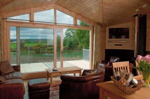 a living room with a large sliding glass door at Fern Lodge - Luxury Lodge with steamroom in Perthshire in Perth