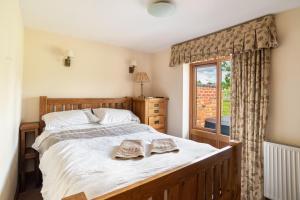 una camera da letto con un grande letto con due asciugamani di Coach House at Oaks Barn Farm Alcester with optional hire Salt water hot tub 