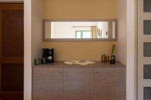 a wooden cabinet in a room with a mirror at Giannoulis - Grand Bay Beach Resort (Exclusive Adults Only) in Kolymvari