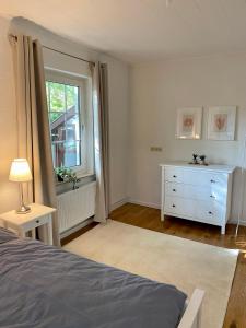 1 dormitorio con 1 cama, vestidor y ventana en Ankerplatz, en Leer