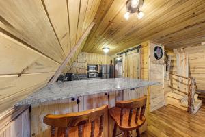 Cabaña de madera con cocina con encimera y 2 sillas en Pinon Pines, en South Fork
