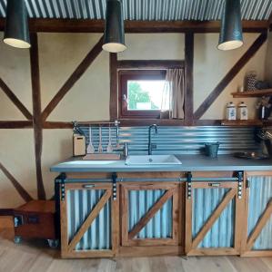 una cocina con fregadero y armarios de madera en La Cabane du Coing, en Visé