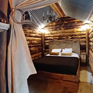 um quarto com uma cama num chalé de madeira em La Cabane du Coing em Visé