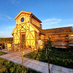 a yellow building with a deck and a table at La Cabane du Coing in Visé