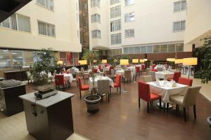 亞的斯亞貝巴的住宿－Cassiopeia Hotel，一间设有白色桌子和红色椅子的餐厅