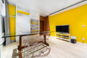 a dining room with a glass table and a television at Maison Giulia ai Giardini in Bologna