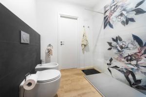 a bathroom with a toilet and a bath tub at Maison Giulia ai Giardini in Bologna