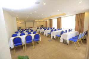 uma sala de conferências com mesas e cadeiras e um ecrã em Cassiopeia Hotel em Addis Ababa