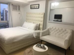 カガヤン・デ・オロにあるCozy Studio Unit @ Centrio Towerのベッドとソファのある白い寝室
