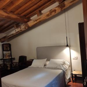Una cama blanca en una habitación con techos de madera. en Zocailla, en Gata
