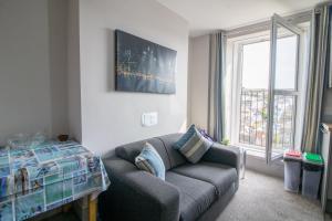 a living room with a couch and a window at Sea La Vie- Cosy, Modern, Harbourside Views in Brixham