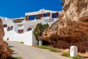 a house on a cliff next to a mountain at Vacaciones en Cala Morell in Cala Morell