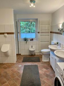 a bathroom with two sinks and a toilet and a window at Ankerplatz in Leer