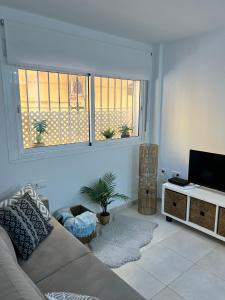 a living room with a couch and a flat screen tv at Fuengirola Paseo Marítimo 27 in Fuengirola
