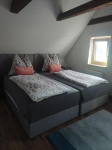 a bedroom with two beds with pillows and a window at Apartments Nähe Red Bull Ring in Proleb