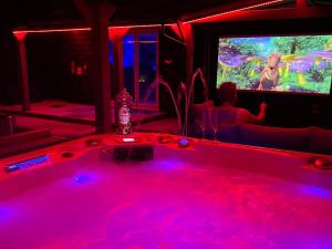 bañera de hidromasaje en una habitación con TV en Hot tub, 110Inch Outdoor Cinema, Fire Pit, 4 Acre garden, Luxury 5 Star Woodland Lodge en Skegness