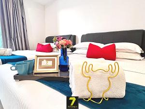 a bedroom with two beds with red pillows at 7Stonez Residences Midhills Genting Highlands in Genting Highlands