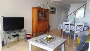 sala de estar con TV y mesa en Modern Duquesa 2 Bed Outstanding view of sea golf en Manilva