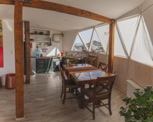Domos by Toore Patagonia في بويرتو ناتالز: مطبخ وغرفة طعام مع طاولة وكراسي